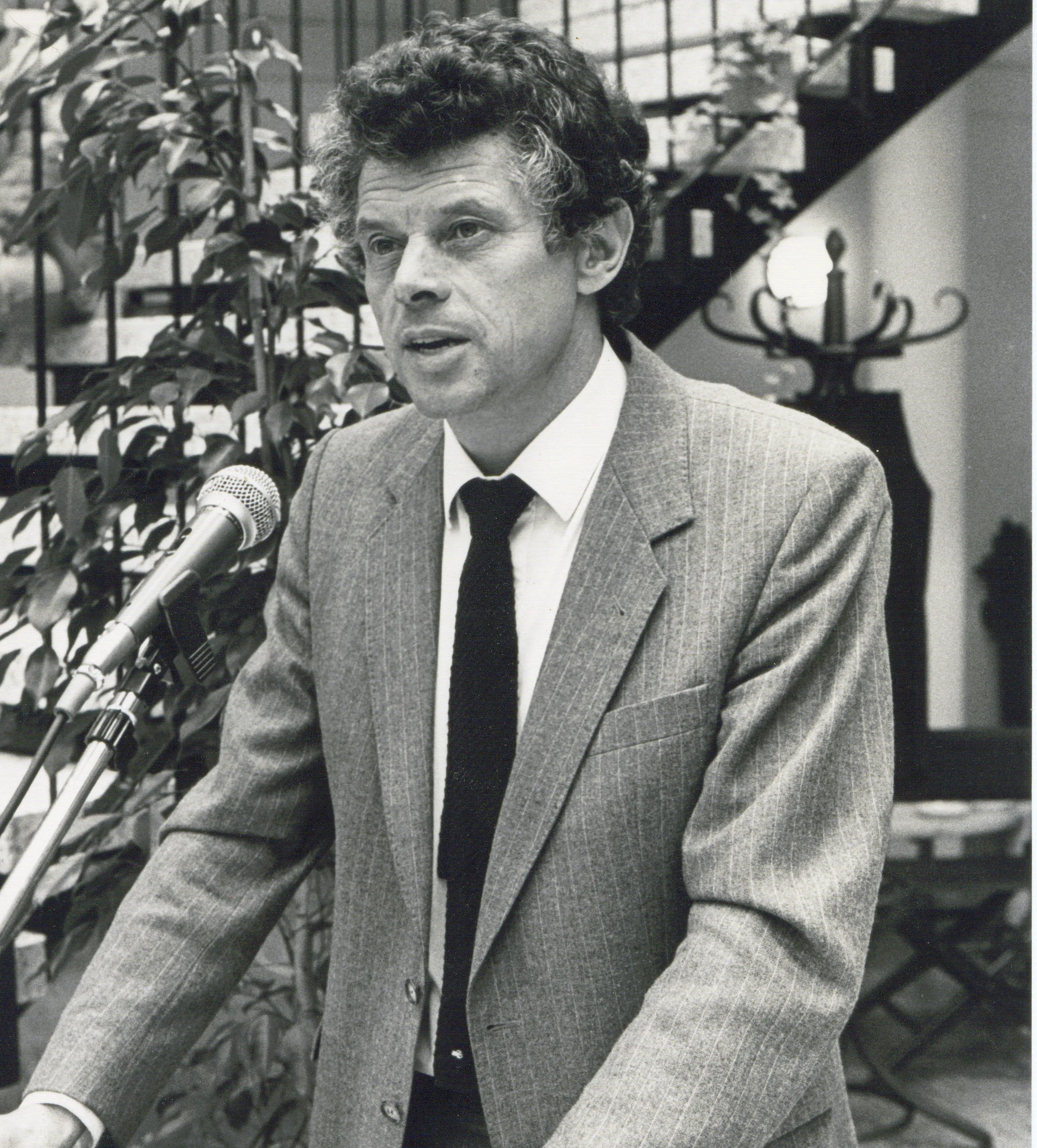 Paul Saatkamp mit Anzug an einem Rednerpult im Lore-Agnes-Haus auf einem schwarz-weiß-Foto